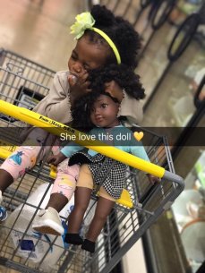 A little girl with a doll that looks just like her.